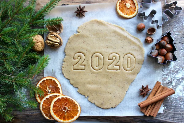 Mesaj 2020. Yeni yıl kavramı 2020. Noel pastaları. Yeni yıl ve Noel için ev yapımı kekler veya kurabiyeler. Resimler, fındıklar, kurutulmuş portakallar, köknar dalları, ahşap arka plan. Kırsal tarzda. Yeni yıl, Noel arkaplanı.