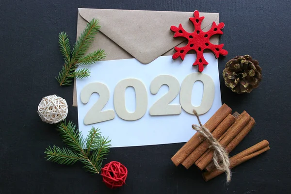2020 yılı. Yeni yıl, Noel kompozisyonu. Sayılar 2020, yeni yıl tebrikleri kavramı. Noel ağacı, kakao, siyah arka planda Noel süslemeleri, bokeh, kar taneleri.