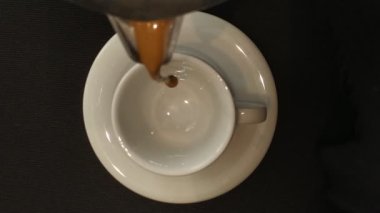 Espresso beyaz bardak içinde şofben kahve makinesi (La Moka) dökülür taze demlenmiş kahve. Üst görünüm.