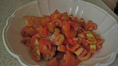 Ekmek ile beyaz bir kapta doğranmış domates. Ekmek, domates ile İtalyan salatası Panzanella hazırlanması.