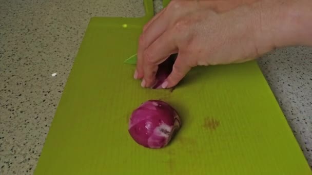 Frauenhände Schneiden Rote Zwiebeln Auf Das Grüne Schneidebrett Nahaufnahmen Zubereitung — Stockvideo
