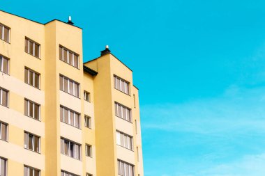 Yeni apartman: sarı renk masmavi gökyüzü karşı çok öykülü bir konut bina.