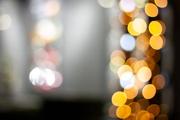 Abstract christmas lights shop windows. Bright circles bokeh from the lights of night windows. Illumination on shop, defocus and blur. Bokeh from the bright garlands of Christmas shop windows.