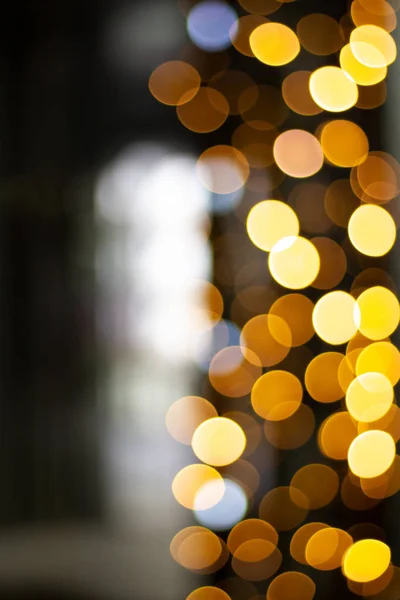 Abstract christmas lights shop windows. Bright circles bokeh from the lights of night windows. Illumination on windows, defocus and blur. Vertical orientation for citylight.