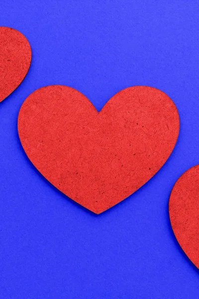 Big red handmade heart on a blue background. Homemade background for Valentine\'s Day cards. Bright red heart on a blue background. Flat lay.