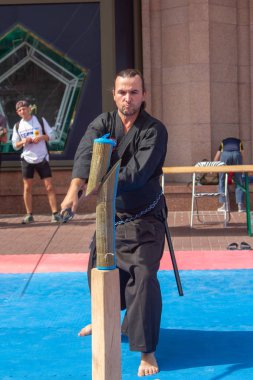 Kiev, Ukrayna, 9 Eylül 2018: Intersport çalışma Ua. Kiev sporun dünya günü. Kılıçla dövüş ustası bambu manken konuşabilerek kılıç bıçakla keser.