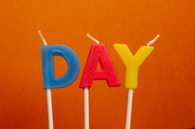 Turuncu zemin üzerine kavramı kelime gün Festival çok renkli balmumu parafin mumlar.