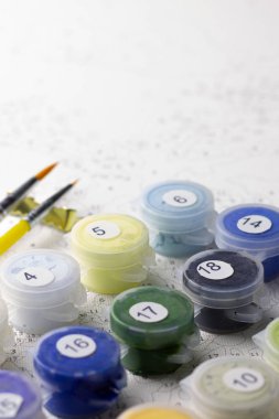 Kapları numaralarına göre ev resim boyaları ile kümesi. Hobi resim tuval ile akrilik rakamlarla boyar. Boya fırçaları ve renkli boyalar. Sanat Paint'i kapatın.