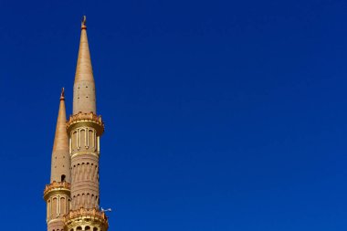 Parlak mavi gökyüzünün arka planı üzerinde antikaltın altın minare. Doğu lezzeti ile Doğu kültürü. Kopyalama alanı ile arka plan.