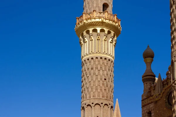 Vintage golden minaret on a background of bright blue sky close-