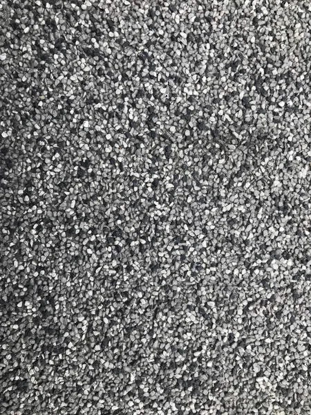 Asphalt texture close up. Gray marble chips on asphalt. Stone natural texture of building material for walls and other surfaces. Gray texture of marble chips and asphalt.