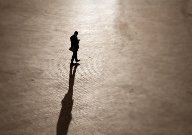Squar bir telefon ile iş elbisesi içinde bir adamın silueti