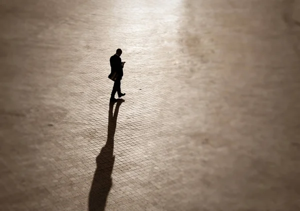 Silhouette eines Mannes im Businessanzug mit einem Telefon im Quadrat — Stockfoto