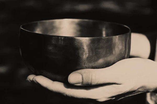 Photo en noir et blanc d'un bol chantant en bronze dans les paumes des femmes . — Photo
