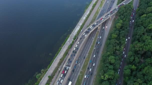 Auto vista aerea guida su autostrada multi-livello a Kiev. Liscio volo drone sulle autostrade con traffico auto vicino al fiume Dnipro la sera di sole . — Video Stock