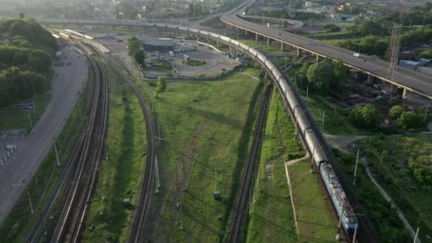Ulaşım otobanlarından oluşan hava panoraması: Elektrikli tren raylarda gidiyor, arabalar şafakta otoyola çıkıyor. Drone 'da çekilen. — Stok video