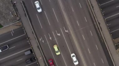 Araç trafiği çok katlı kavşağın üst görüntüsünde. Otoyolların kesişiminde saat yönünde bir dönüşle trafiği tepeden tırnağa vurmak.