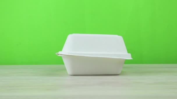 Einweg-Eco-Karton Lebensmittelbehälter. Dolly Out Schuss mit grünem Hintergrund. Das Konzept der Essensausgabe mit einem Platz für das Logo und die Marke. — Stockvideo
