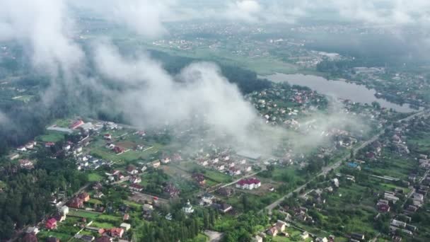 Nebelschwaden über der malerischen, umweltfreundlichen Wohngegend. Niedrige Kumuluswolken über Wohnhäusern am Stadtrand. — Stockvideo