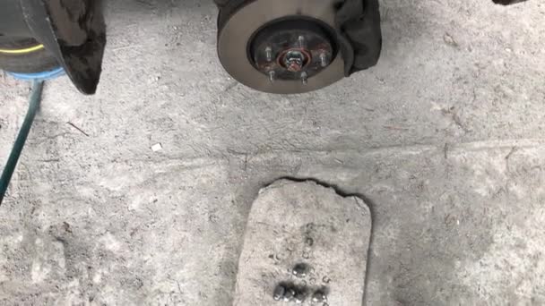 Inspección del disco de freno del coche con la rueda extraída, levantada sobre el gato — Vídeo de stock