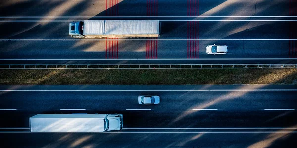 Camions de circulation et voitures sur l'autoroute avec des marques blanches. Vue de dessus. Photo de drone. — Photo