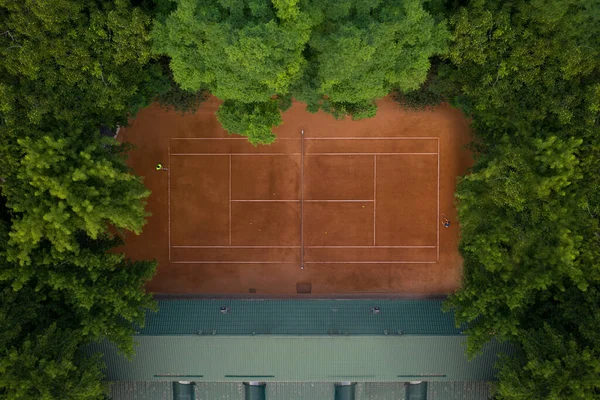 Terrain de tennis en argile avec des joueurs qui sont formés pour jouer au tennis. Entraînement des joueurs sur la base du court de tennis. — Photo