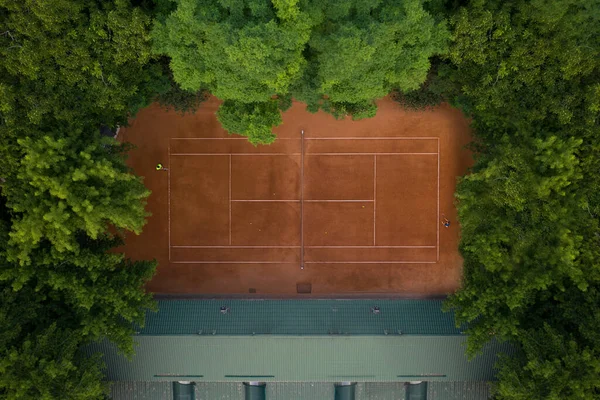 Tenis oynamak için eğitilmiş oyuncularla tenis sahası. Oyuncular tenis kortuna göre antrenman yapıyor..