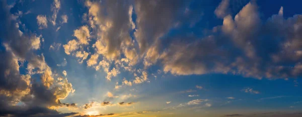 夜明けの青い空の壮大な魔法のパノラマでの太陽光線と暖かい雲 — ストック写真