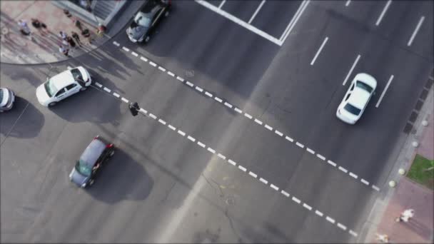 Az emberek átkelnek az úton egy gyalogos átkelőhelyen. Drónra néző. Forgalom a zebránál. Autók haladnak át a kereszteződésen.. — Stock videók