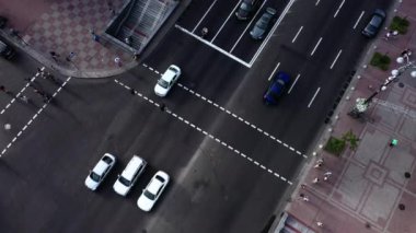 Yaya geçidinin yakınındaki caddede trafik vardı. Arabalar ve diğer araçlar dört şeritli bir yolda seyahat ederler. Drone görünümü.