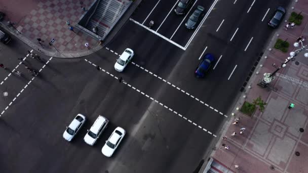 Tráfico de coches en la calle cerca del paso de peatones. Los coches y otros vehículos viajan por una carretera de cuatro carriles. Vista del dron . — Vídeo de stock