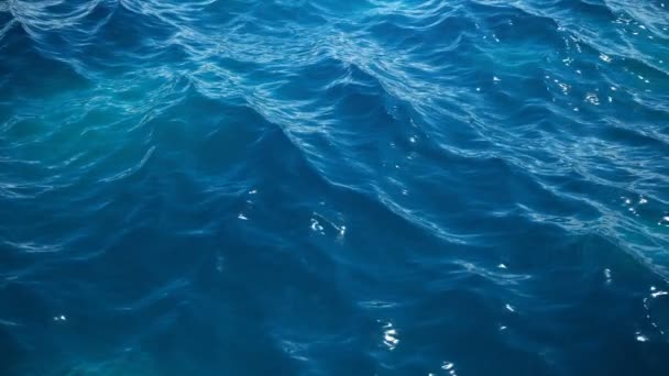 Θάλασσα ή ωκεανός, κύματα κοντά στην θέα. Μπλε κύματα θαλασσινό νερό. Μπλε κρυστάλλινα νερά. Μπορεί κανείς να δει τον αμμώδες βυθό. Θέα σε χαμηλή γωνία. κίνηση 3D 4K — Αρχείο Βίντεο
