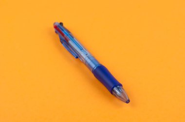 Bir mavi şeffaf multi renk tükenmez turuncu Kağıt arka plan üzerinde