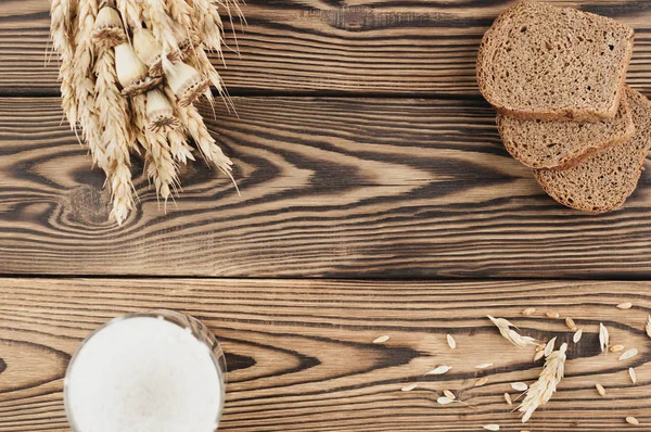 Jeden Uzlík Pšenice Máky Spousta Roztroušeného Obilí Tři Plátky Chleba — Stock fotografie