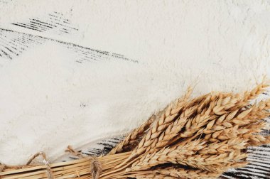 Eski rustik ahşap kalaslar üzerinde buğday ve haşhaş ve serpiştirilmiş un bir demet