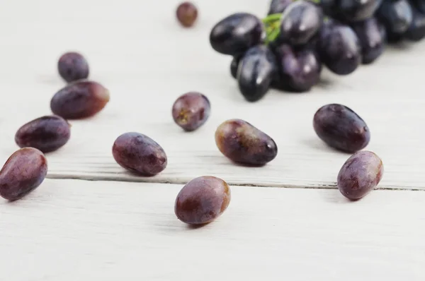 Rozproszone Winogrona Obok Grona Świeżych Dojrzałych Winogron Niebieskich Starych Drewnianych — Zdjęcie stockowe