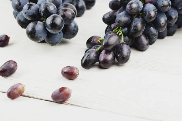 Uvas Espalhadas Lado Cachos Uvas Frescas Maduras Azuis Velhas Tábuas — Fotografia de Stock