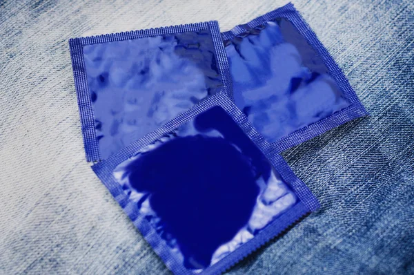 Três Preservativos Folha Pacote Azul Espalhados Jeans Novos Azuis — Fotografia de Stock