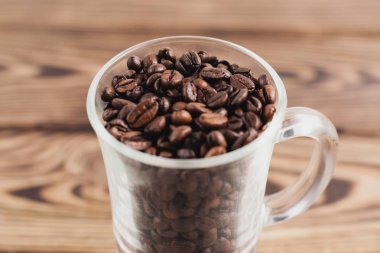 Eski ahşap rustik kahverengi plakalar üzerinde kolu ile mulled şarap için şeffaf cam kızarmış kahve çekirdekleri Çok. Close