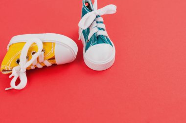 Kırmızı kağıt üzerinde yeni sarı ve yeşil renkli spor ayakkabı çifti