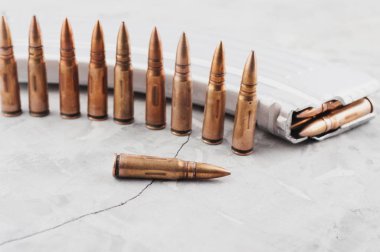 Eski gri kırık beton üzerinde saldırı tüfeği ve mermi satır için Gümüş tam dergi