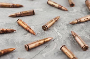 Eski kırık gri beton üzerinde saldırı tüfeği için birçok dağınık metal mermi