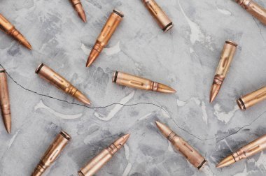 Eski kırık gri beton üzerinde saldırı tüfeği için birçok dağınık metal mermi