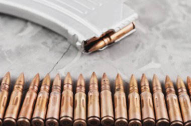 Eski gri kırık beton üzerinde saldırı tüfeği ve mermi satır için Gümüş tam dergi