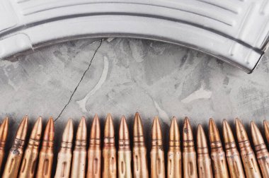 Eski gri kırık beton üzerinde saldırı tüfeği ve mermi satır için Gümüş tam dergi