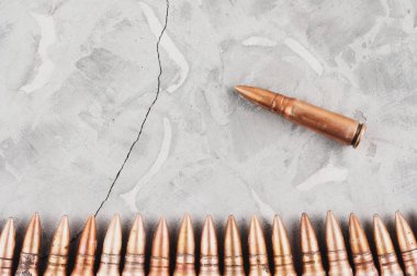 Eski gri kırık beton üzerinde mermi satır ve tek mermi