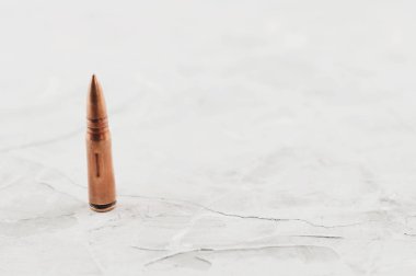 Eski gri kırık beton üzerinde saldırı tüfeği için bir metal mermi