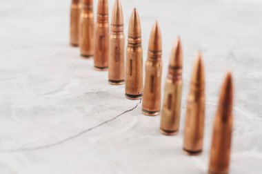 Eski gri kırık beton üzerinde birçok metal mermi Satır