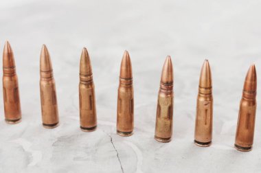 Eski gri kırık beton üzerinde birçok metal mermi Satır