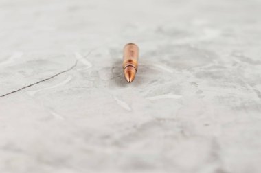 Eski gri kırık beton üzerinde saldırı tüfeği için bir metal mermi